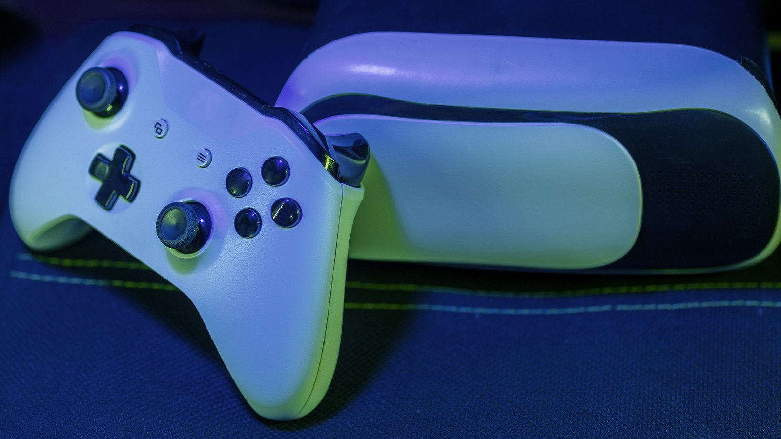 White game controller on a dark desk, lit from the side